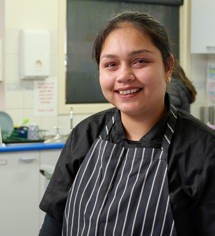 Cook smiling at the camera in a kitchen