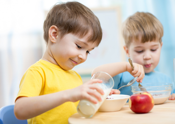 young boys pouring milk