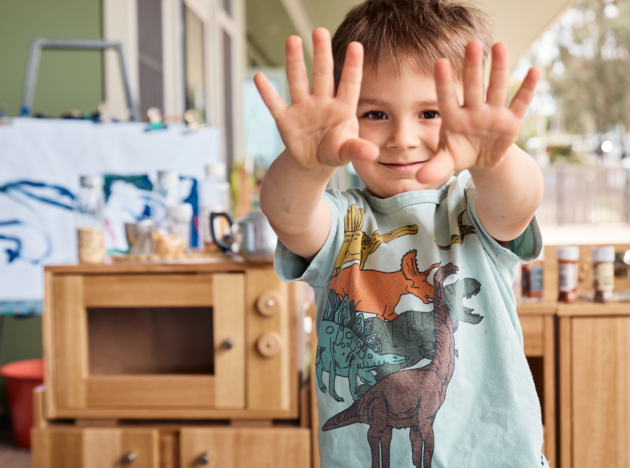 Kid at an early learning centre showing his clean hands