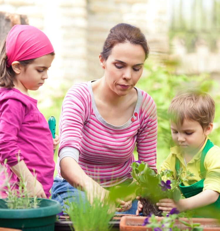 adult showing kids how to garden