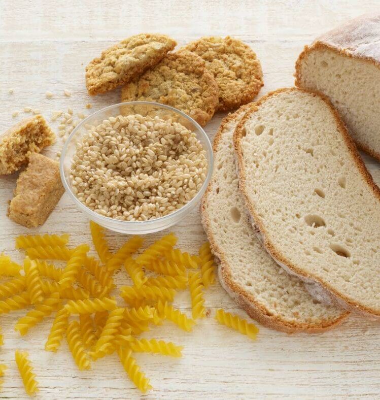 table with sliced bread, pasta, rice and biscuits