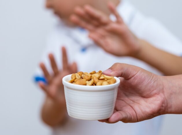 Child in the background rejecting a bowl of mixed nuts