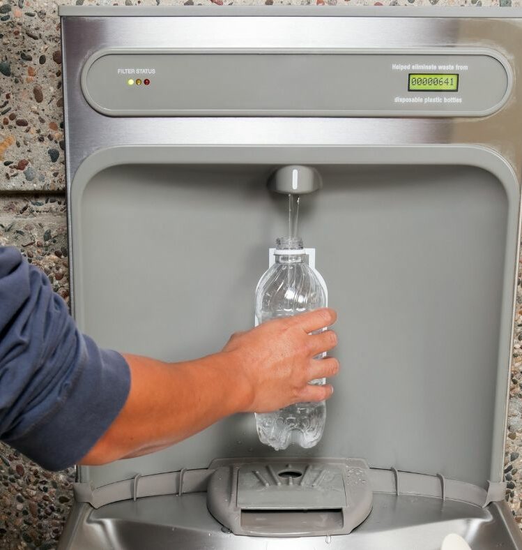 Man filling a water bottle from a tap