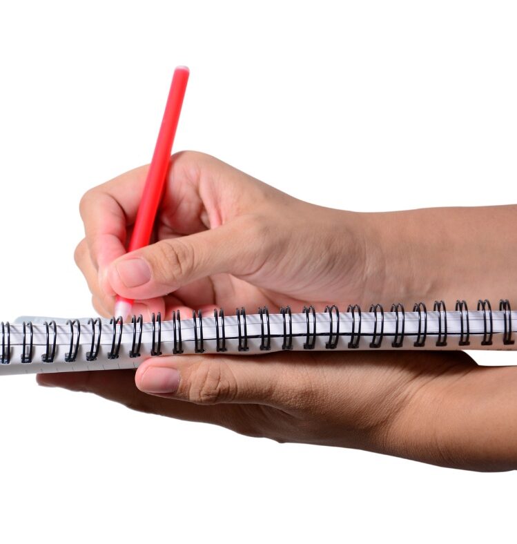 Hands holding a notepad and red pen