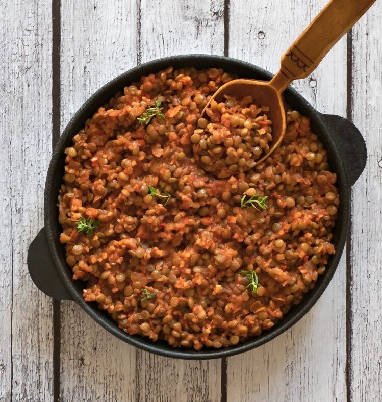 Pan of vegetarian lentil bolognese on wooden table