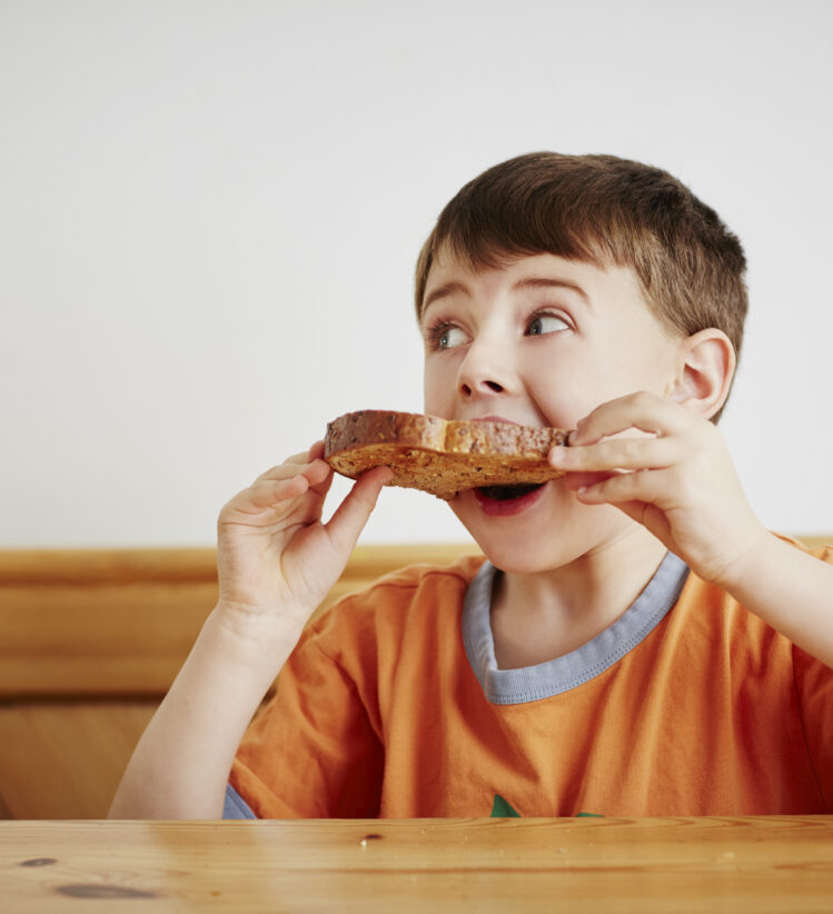 boy eating piece of toast