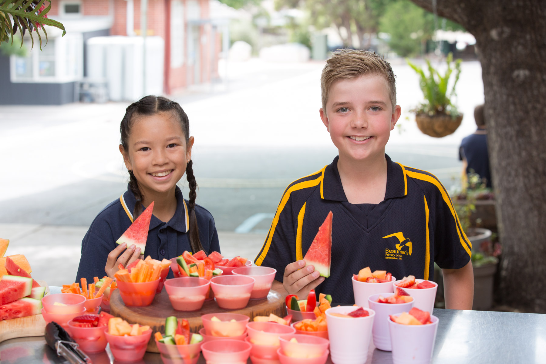 Students with watermelon slices in their hands at the school canteen