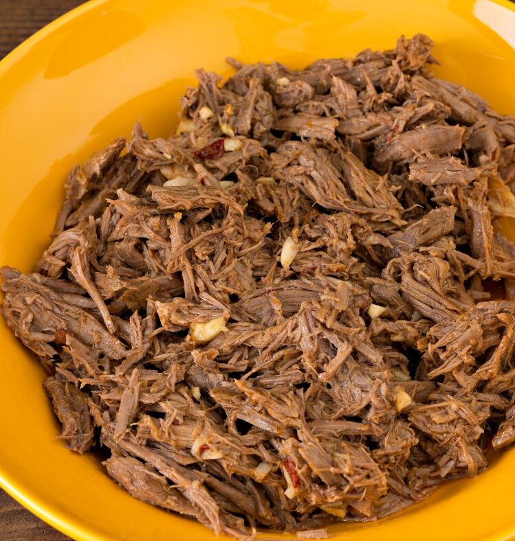 Pulled braised lamb shoulder in a yellow bowl