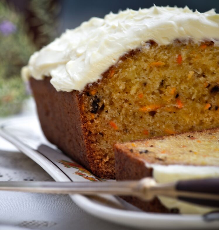 a carrot cake with icing sliced through the middle