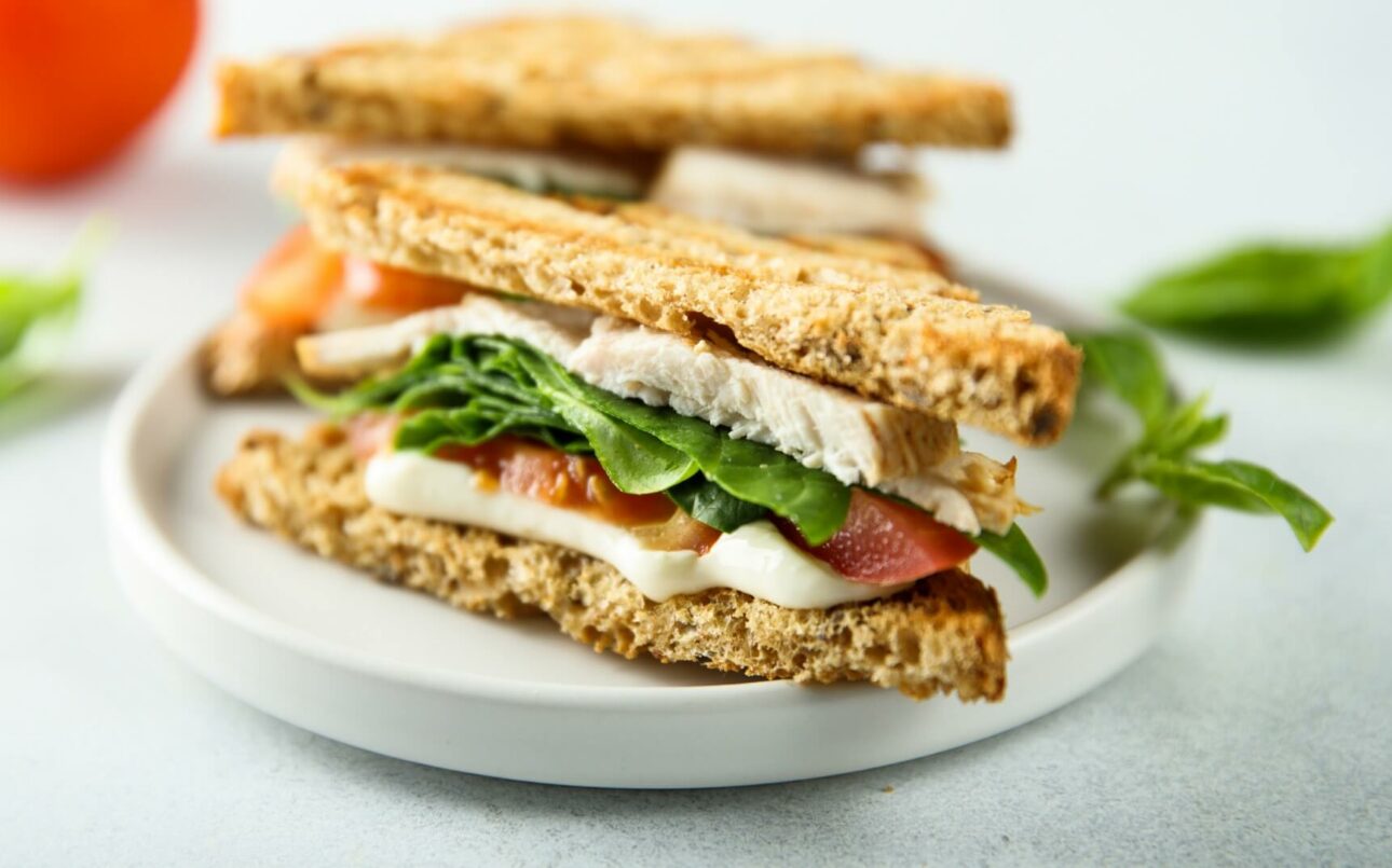 a dijon and herb chicken Turkish bread sandwich cut into triangles