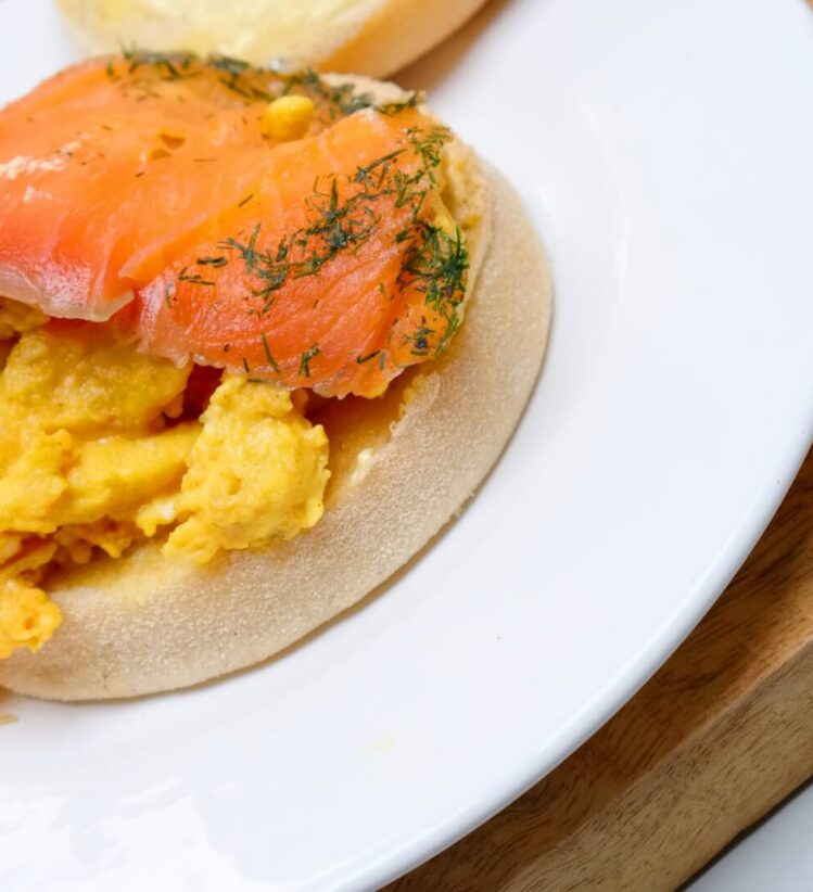 English muffin with avocado and smoked salmon on a plate