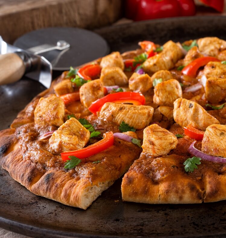 Sliced pizza with poached chicken pineapple and capsicum