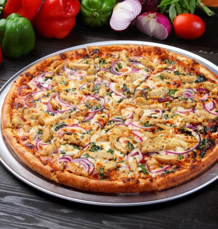 Pulled pork pizza with feta red onion and rocket served on table