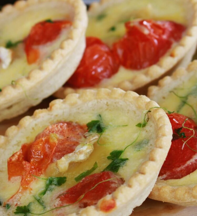 two rows of mini chicken and cherry tomato quiches