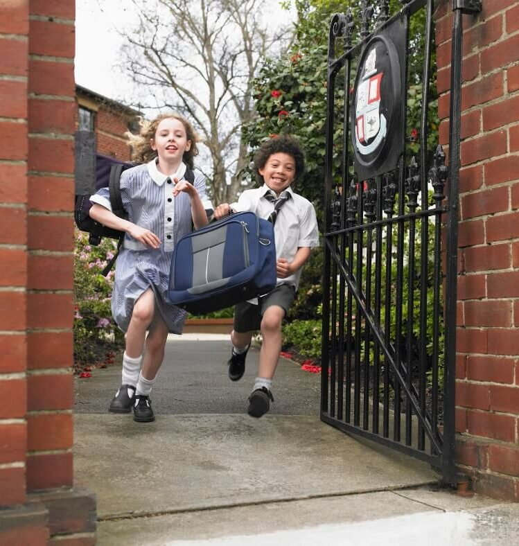 two children running out a school gate