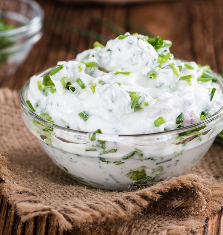 Small glass bowl filled with herbed yoghurt dip