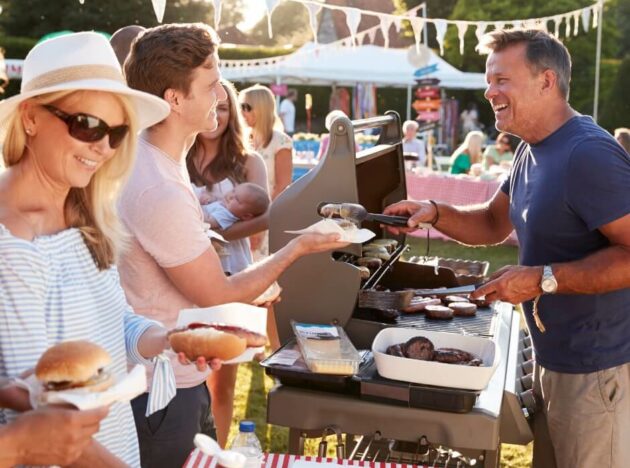 a person serving food at a barbeque