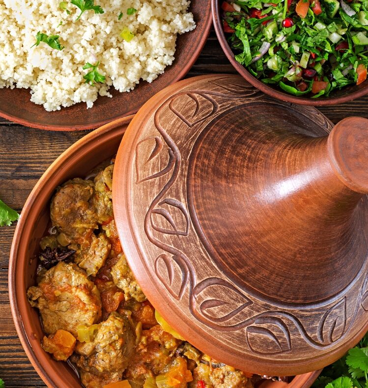 Persian chicken and tomato tagine in a brown pot with a cylindrical handle