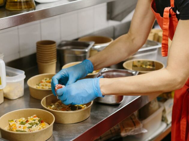 a person preparing food in takeaway containers