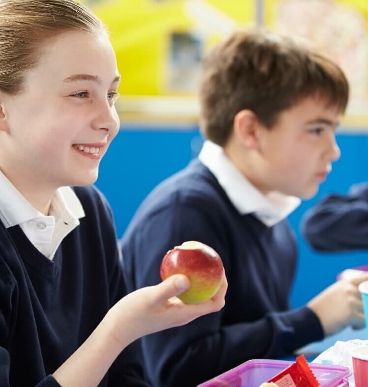 student holding a bitten apple