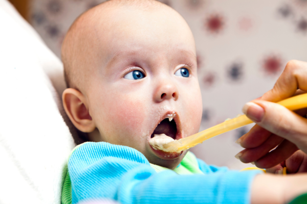 Baby being fed mashed food