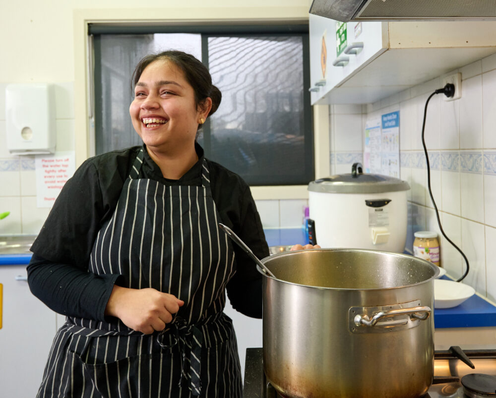 Childcare chef cooking in kitchen with large pot