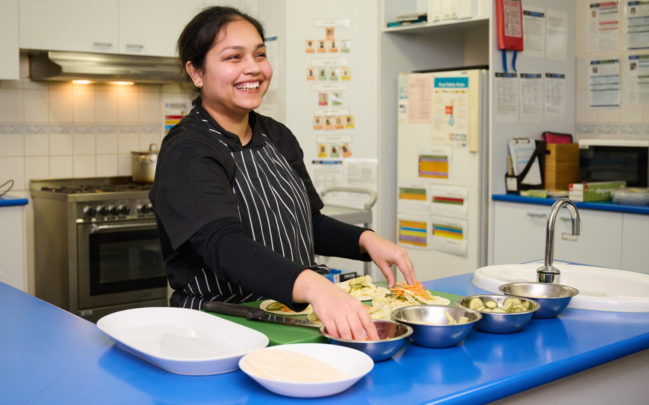 Cook at a long day care preparing wraps
