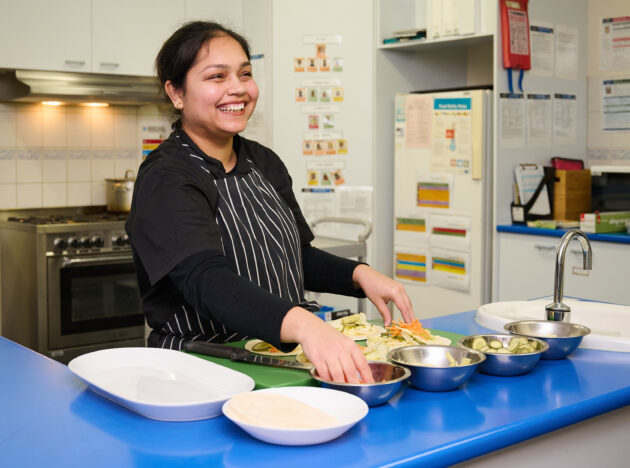 Cook at a long day care preparing wraps