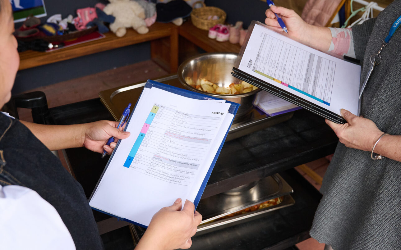 Two people reading through a checklist in the kitchen